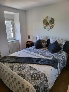 una camera da letto con un letto con una coperta e una finestra di Les appartements du Marché a Dinan