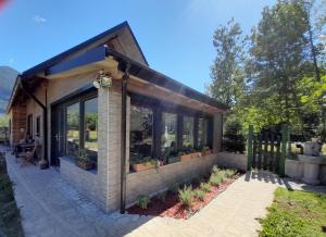 a tiny house with a greenhouse in the yard at Apartments Radulje Bovec in Bovec