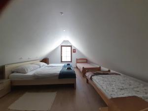 a attic bedroom with two beds and a window at Apartments Radulje Bovec in Bovec