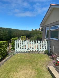 una cerca blanca frente a una casa en Crossroads, en Holyhead