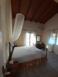 a bedroom with a large white bed with a window at Evdilos' Balcony in Evdilos