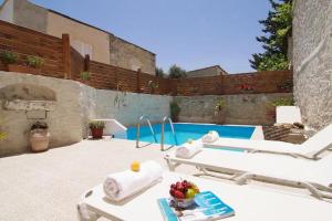 a patio with a swimming pool and a hot tub at Villa Maris in Melissourgákion