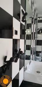 ein Bad mit einer schwarz-weiß karierten Wand in der Unterkunft M & M in Izola