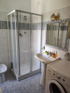 ein Badezimmer mit einer Dusche, einem Waschbecken und einer Waschmaschine in der Unterkunft Casa Vacanze Palena Adventures in Palena