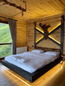 a bedroom with a bed in a wooden cabin at Nirvana dağ evleri in Çamlıhemşin