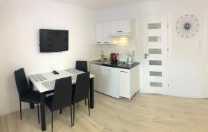 - une cuisine et une salle à manger avec une table et des chaises dans l'établissement Apartament Jarzębinka, à Międzyzdroje