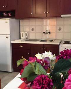 a kitchen with purple cabinets and flowers on a table at Barbara's one bedroom apartments in Argostoli