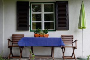 einem blauen Tisch mit zwei Stühlen und einem Fenster in der Unterkunft Ländliches Ferienhaus in Kötschach