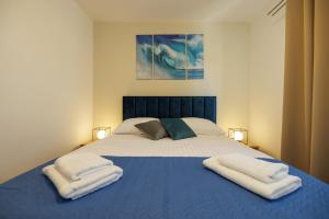a bedroom with a bed with two towels on it at Apartman La vista e' bella in Kornić