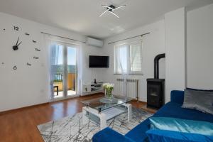 a living room with a blue couch and a table at Apartman La vista e' bella in Kornić