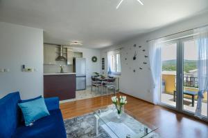 a living room with a blue couch and a table at Apartman La vista e' bella in Kornić