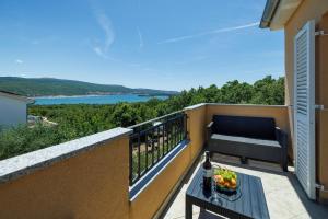 a balcony with a table and a view of the water at Apartman La vista e' bella in Kornić