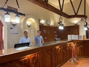 two men standing at a bar in a restaurant at Dream Lagoon Resort & Aqua Park in Marsa Alam City