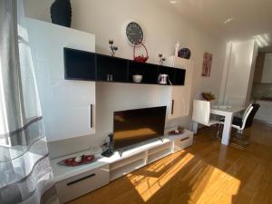 Una sala de estar con televisión y una mesa de comedor. en Apartman Mrdic, en Trebinje