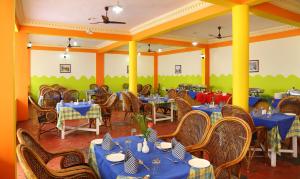 uma sala de jantar com mesas e cadeiras azuis em Jasmine Palace em Kovalam