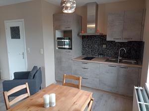 a kitchen with a wooden table and a dining room at Au Bon pl'Han in Han-sur-Lesse