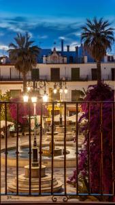 una calle de la ciudad con palmeras y un edificio en Hotel Barrameda, en Sanlúcar de Barrameda