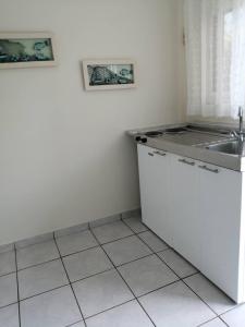 uma cozinha branca com um lavatório e um balcão em Villa Sophia em Mitikas