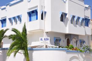 a hotel with a swimming pool in front of a building at Al Alba in Asilah
