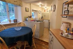 a kitchen with a table and a kitchen with a stove and a table and chairs at Anne Cottage, Bakewell, in the Peak District in Bakewell