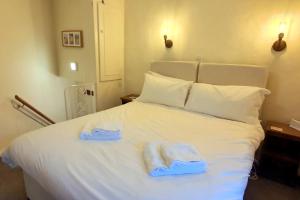 ein Schlafzimmer mit einem weißen Bett und Handtüchern darauf in der Unterkunft Anne Cottage, Bakewell, in the Peak District in Bakewell