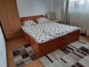 a small bedroom with a bed with a wooden frame at Casa Lica in Căciulata