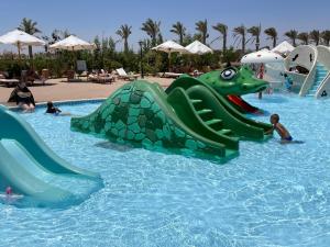 a water slide in a pool at a resort at Dream Lagoon Resort & Aqua Park in Marsa Alam City