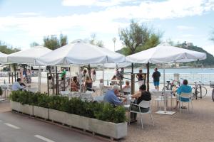 a group of people sitting at tables under white umbrellas at Hotel Niza in Donostia-San Sebastián
