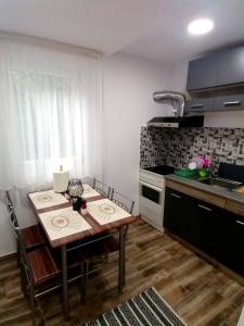 a kitchen with a wooden table and a kitchen with a stove at Casa Ema in Orşova