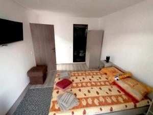 um quarto com uma cama e uma televisão de ecrã plano em Casa Ema em Orşova