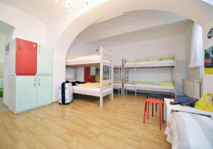 a room with three bunk beds and a table and chairs at Hostel Temza in Zagreb