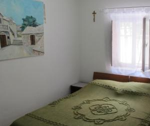 a bedroom with a bed with a cross on the wall at Guesthouse Ursic in Selca
