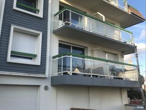 una casa con un balcone in vetro sul lato di Les Bains de Wimereux a Wimereux