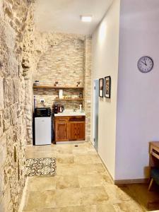 een keuken met een witte koelkast en een stenen muur bij Christian Quarter Studio I in Jeruzalem