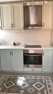 a kitchen with white cabinets and a stove top oven at Barbara΄s Apartments in Argostoli