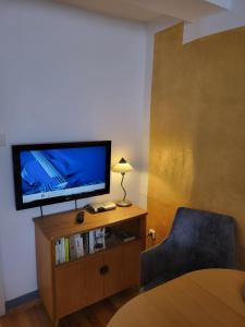 um quarto com uma televisão de ecrã plano e uma cadeira em Gästehaus Domänenblick em Morschen