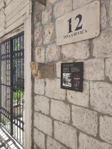 una pared de piedra con un cartel en un edificio en Guest House Exalto, en Trogir