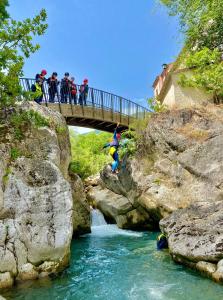 Eine Gruppe von Menschen auf einer Brücke über einen Fluss in der Unterkunft Casa Vacanze Palena Adventures in Palena