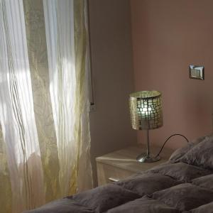 ein Schlafzimmer mit einem Bett und einer Lampe neben einem Fenster in der Unterkunft Terrazza sul Mare in Giulianova