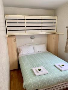 a bedroom with a bed with two towels on it at Tatura Cabin & Caravan Park in Tatura