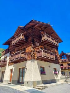 a building with wooden balconies on the side of it at Chalet Armony in Livigno