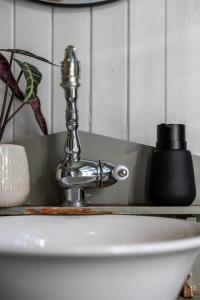 a silver faucet on top of a white sink at Feriehus med flott havutsikt ved Hauklandstranden in Leknes