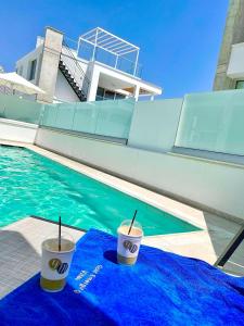 duas chávenas numa toalha azul ao lado de uma piscina em Imperial Jade Villas Gold Emerging Villas 2 em Protaras