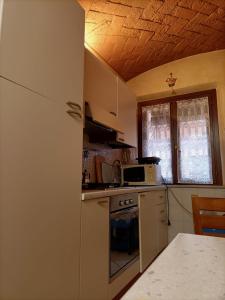 una cucina con frigorifero e piano cottura forno superiore di Il Gioiellino di Modena - Elegant Apartment[☆☆☆☆☆] a Modena