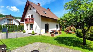 uma grande casa branca com um jardim de relva em Dom u Gazdy przy Gondoli em Szczyrk