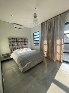 a bedroom with a bed and a large window at 365@ Vaal De Grace Parys in Parys