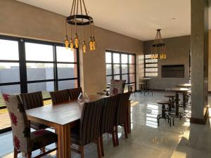 a dining room with a table and chairs and windows at 365@ Vaal De Grace Parys in Parys +7 photos