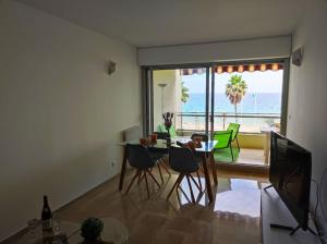 - un salon avec une table et des chaises et une vue sur l'océan dans l'établissement Cnossos YourHostHelper, à Cannes