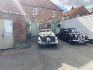 two old cars parked next to a brick building at The Olive in Market Rasen