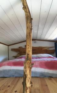 a tree in front of a bed in a room at La pause tiny in Ploërmel